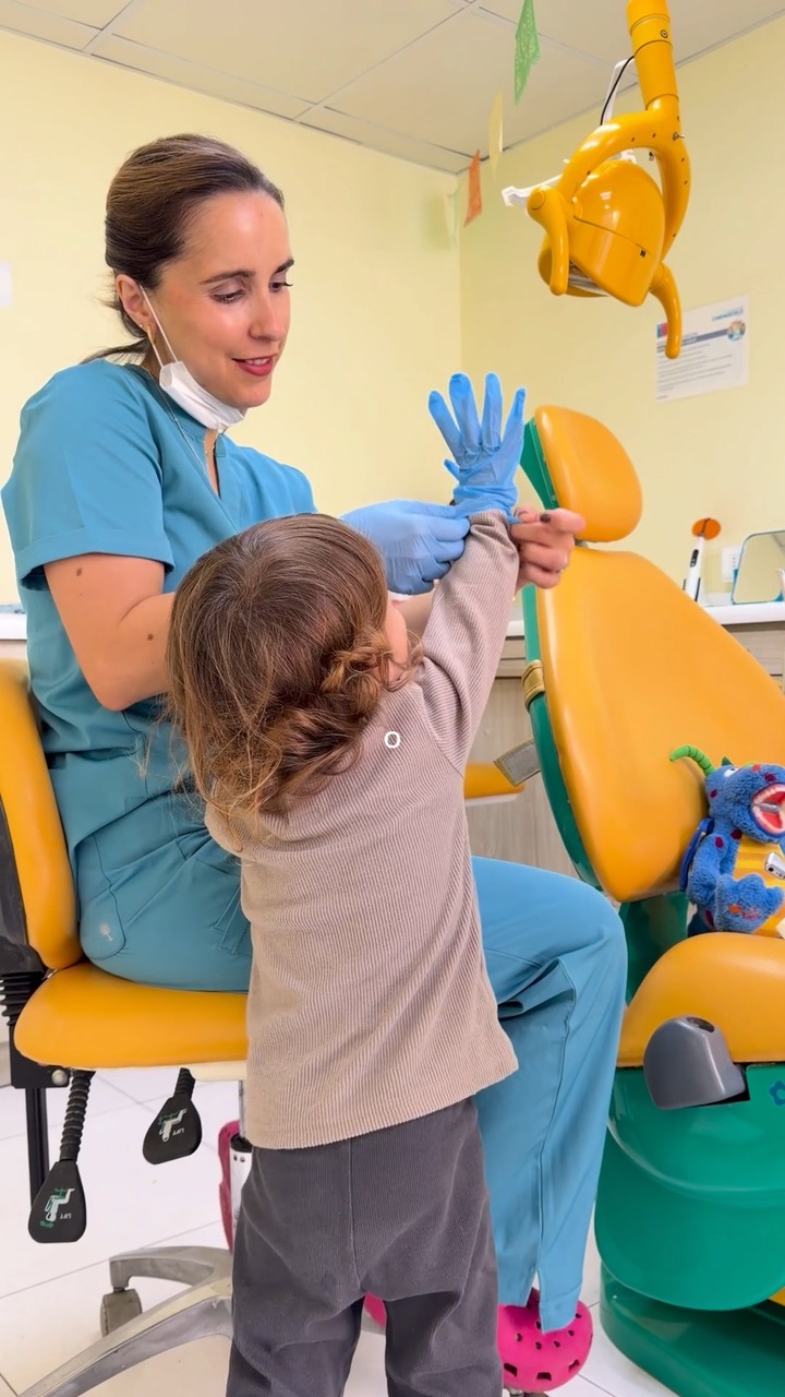Odontopediatra jugando con una niña antes de la atención